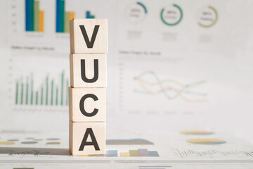 VUCA, abbrevation on wood blocks on a light financial background