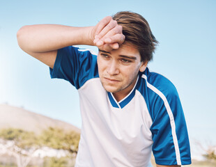 Man, tired with face and soccer player on outdoor field, playing game or football training with energy and exhausted athlete. Team sport, sweating and fitness, challenge and fatigue with workout