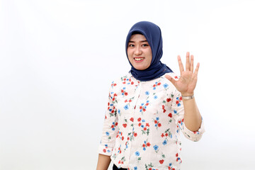 Happy asian muslim woman standing while showing five fingers. Isolated on white background