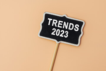 TRENDS 2023 - text on a small chalkboard on a beige background. Top view. Business management, Inspiration to success ideas