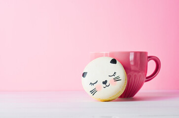 Adorable Cat Macaron Cookies, French Dessert with Pink Cup on Bright Background