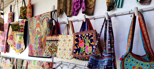 Colorful traditional embroidery handbags hung for display at a local market in India