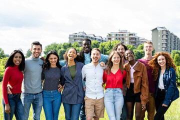 Happy group of multiracial young friends, diverse people smiling at camera outside, international community and joyful people
