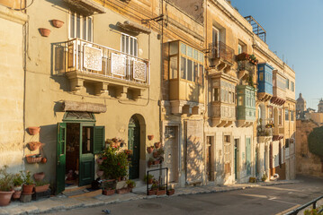 Fototapeta na wymiar Colorful traditional Maltese balconies in Valletta. Street at sunny day