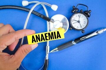 a stethoscope, an alarm clock and a pen with the word Anaemia