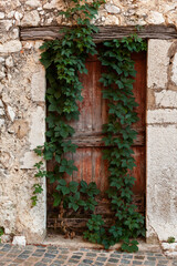 Fototapeta na wymiar Abandoned wooden door in an ancient stone building