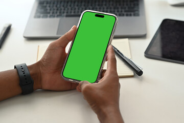 Man sitting at modern workplace and using smart phone. Close up view, empty screen for your advertise design