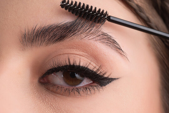 Closeup eyebrows with eyebrow brush. Close up brows, eyebrows lamination. Brow procedures. Long eyelashes, eyebrows, macro.