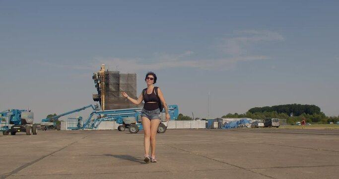 The girl makes dance moves. He moves his arms and legs, motivation is positive. The joy of visiting a musical venue. On the background of the scene. CZ, Milovice, 6.8.22 Let it Roll