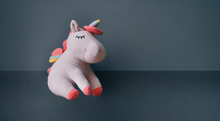 Cute soft unicorn plush toy. Close up shot, empty space