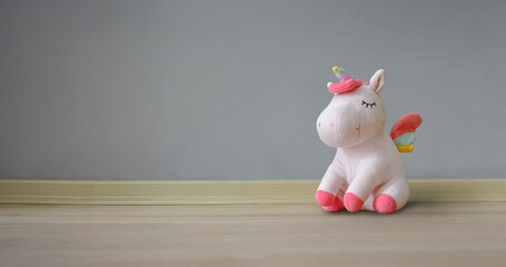 Cute soft unicorn plush toy on the floor. Close up shot, empty space © elif