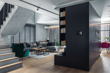 Stylish composition of living room interior with corner grey sofa, green velvet armchair, coffee table, wooden floor,  design furniture and minimalist personal accessories. Modern home decor. Template