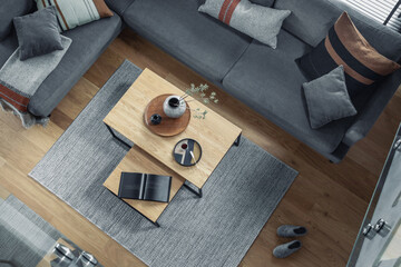 Stylish top view composition of living room interior with corner grey sofa, coffee table, carpet...