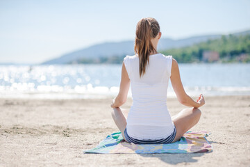 Frau von hinten bei Meditation und Ruhe genießen am Lago Maggiore See in Italien im Urlaub