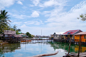Fototapeta premium Wooden houses on stilts, tropical village on the sea shore.