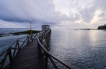 Obraz premium Beautiful landscape. Sunset on the seashore. Wooden bridge on Cloud Nine beach, Siargao Island Philippines.