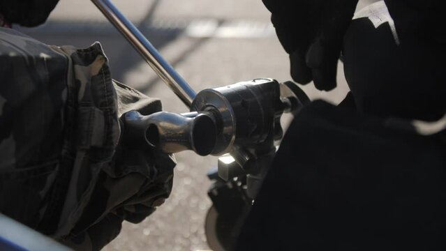 Staff adjusts holder for camera on filming set and prepares tools for shooting. Crew installs camera holder for smooth filming