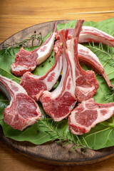 Australian lamb rack cutlets or Raw Frenched Rack 8 Ribs with potato, Rosemary on wooden plate.