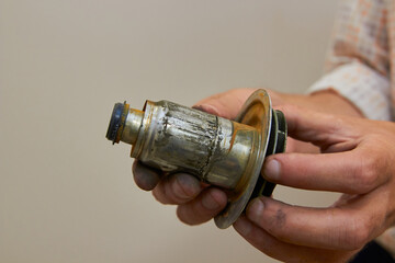 a man holds a broken pump part,the plumber holds a broken rotor of a circulation water pump in his...