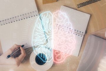 Multi exposure of woman's writing hand on background with brain hologram. Concept of brainstorming.