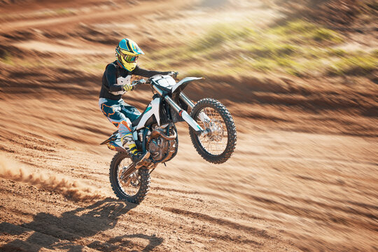 Motorcycle, dirt track stunt and air jump in desert, sand trail and freedom. Driver, cycling and offroad freedom, sports competition and motorbike performance on adventure course for fast action show