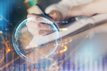 Double exposure of hands making notes with world map hologram and data theme icons. Concept of international network data.