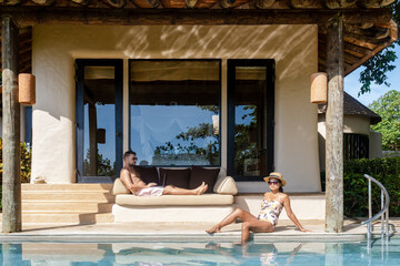 men working at laptop digital nomad ,men and women at a swimming pool during a vacation remote...