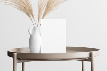White invitation card mockup with a pampas decoration on the beige table. 5x7 ratio, similar to A6,...