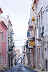 Fototapeta premium An empty old street leading to the ocean, in the historic center of the Nazare