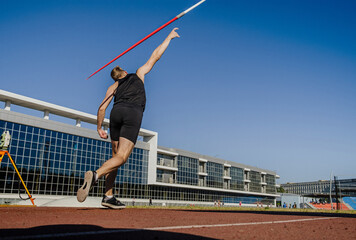 back male athlete javelin throw at athletics competition