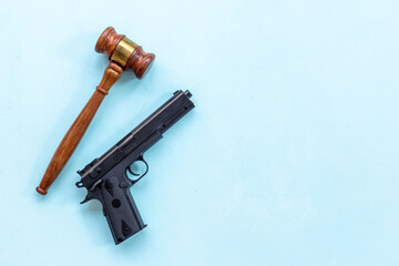 Hand gun weapon and judges gavel - gun law. Illegal use of weapons concept