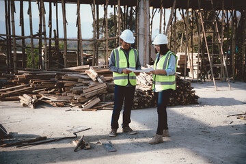 Two specialists inspect commercial, Industrial building construction site. Real estate project with civil engineer, designing commercial buildings on paper. Skyscraper concrete formwork frames.