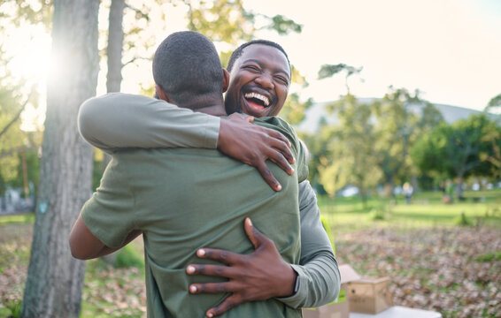 Charity, happy and hug with volunteer friends in a park for community, charity or donation of time together. Support, teamwork or sustainability with a black man and friend hugging outdoor in nature