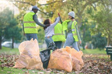 Volunteer, child and people high five while cleaning park with garbage bag for a clean environment....