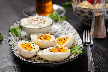 Boiled eggs with yogurt, peppers, parsley and cup tea. Healthy diet food for breakfast.