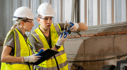 Engineer manager and female technician use equipment tools in metalwork. Vernier calipers are...