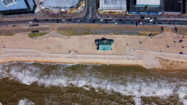 pier overhead view. Birds flying on the Ferris wheel and the pier. Waves crashing on the shore in the blue sea