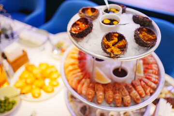 sea urchins, shrimp and shells with oysters on a platter with ice.