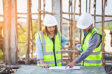 Fototapeta premium Professional team engineers holding blueprint project working outdoors building side with blueprints. engineering and architecture concept.