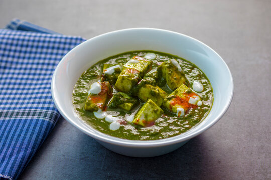 "Palak Paneer" Indian food made of spinach and cottage cheese with a white ceramic plate. 