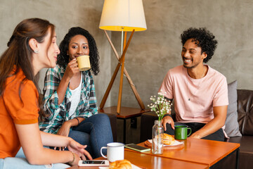 fun friends having fun and drinking coffee sitting in sofa