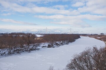 Fototapeta na wymiar 川が雪に覆われて凍った冬の景色