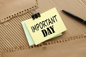 importany day. text on yellow sticky note on brown background. Business concept.