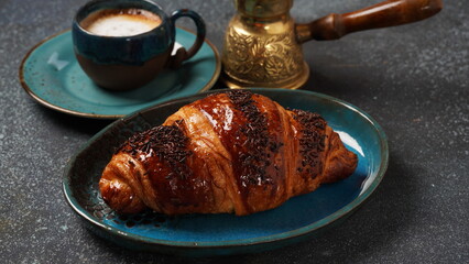 Fresh croissant with a cup of coffee,  on gray background