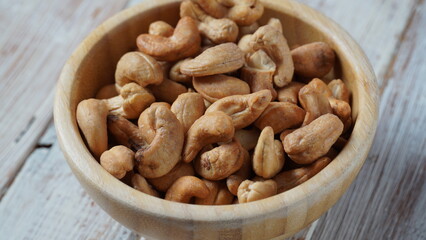 Wooden bowl with mix nuts:  Walnut, pistachios, almonds, hazelnuts and cashews on a table
