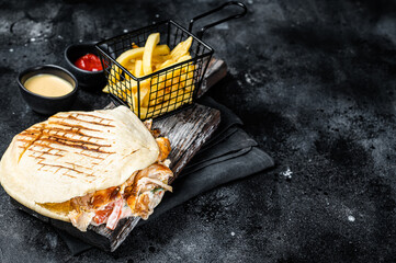 Turkish doner kebab in grilled pita bread with chicken meat. Black background. Top view. Copy space