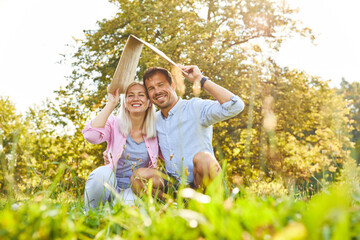 Couple with a roof over their heads as a symbol for building a house