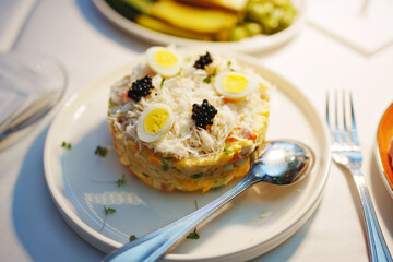 table setting. salad with seafood and quail egg on a round plate. 