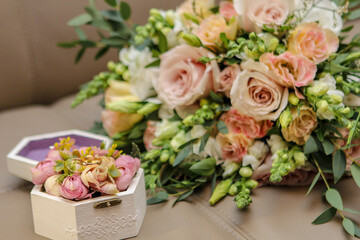 Wedding photography. Photo of a bouquet of flowers and a ring. Wedding rings in a box. Flowers. Wedding. A bouquet of flowers.