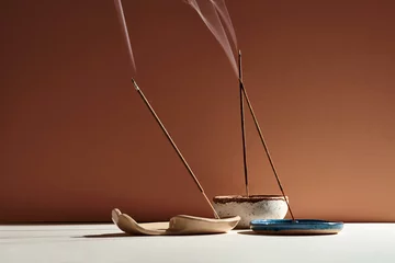 Fotobehang A set of burning incense for yoga or meditation. Minimalistic concept with warm colors © ismishko
